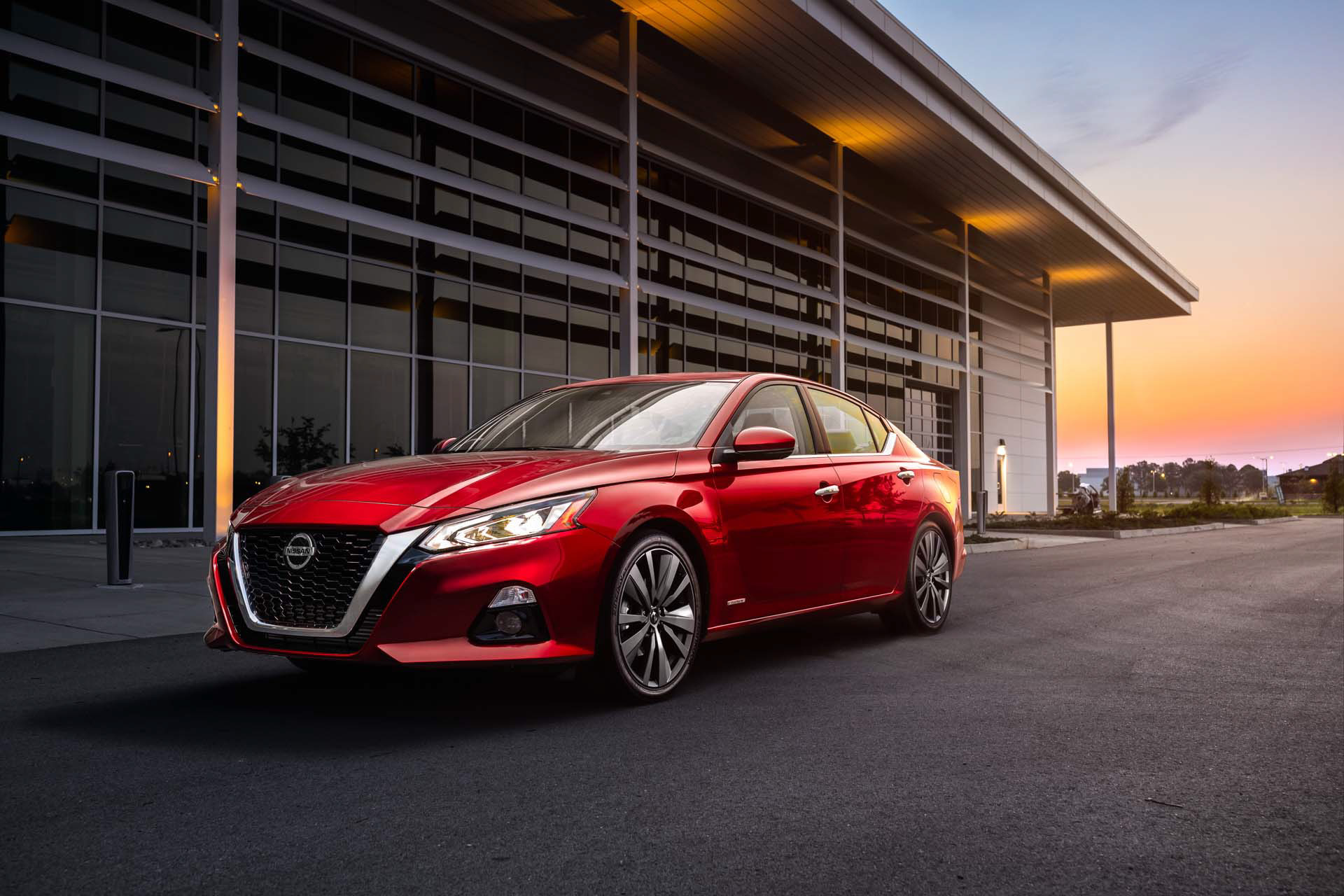 Red Nissan Altima outside a dealership